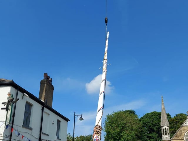 People lined the street to watch the raising of the maypole.