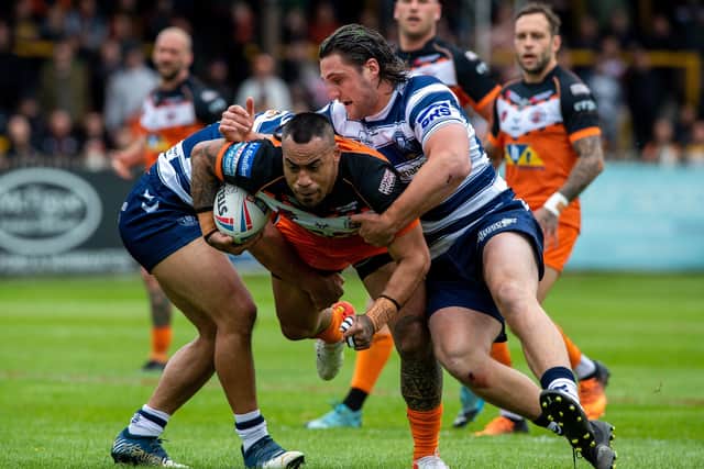 Castleford Tigers' Mahe Fonua is stopped by Wigan's Willie Isa and Jai Field.
 Picture: Bruce Rollinson.