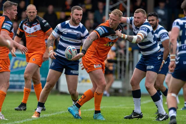 Castleford Tigers' Joe Westerman off-loads as Wigan's Brad Singleton attempts to tackle. Picture: Bruce Rollinson.