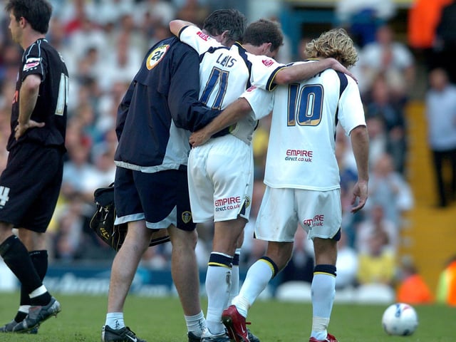 Injured Eddie Lewis is helped off the pitch.