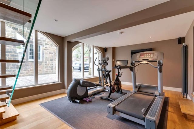 Across from the house is a home office finished in fine walnut units with an integral contemporary fireplace with a gym below -perfect for those working from home.