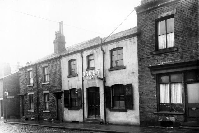 Four properties on Enfield Road pictured in January 1961. Number 12 had been a small Jewish bakery, business of F. Cohen. Signs for Daren Bread and Turog flour can be seen.