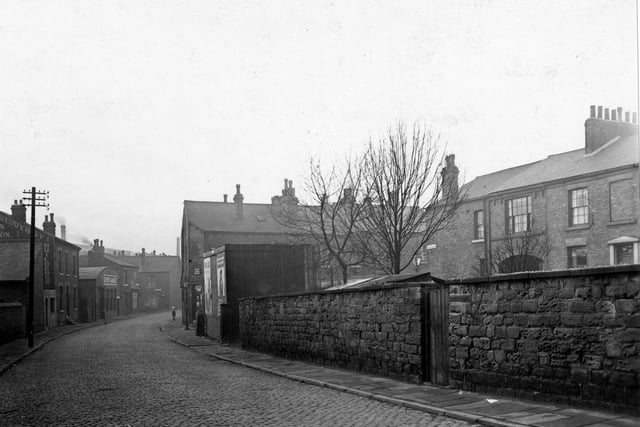 Buslingthorpe Lane with Macedo Terrace to the right pictured in January 1952. On the left side of the photograph can be seen 'F. Reddyhoff & Sons, builders'. Further down is 'Lewis's (Leeds) Ltd., garages'. On the corner of Goxhill Place a sign for 'Boot & Shoe Repairs' can be made out above the door.