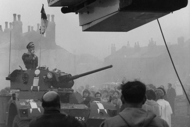 In this scene, Billy (played by Tom Courtenay) is standing in the turret of an armoured car as it is driven through the streets of the ruined city of his dreams.