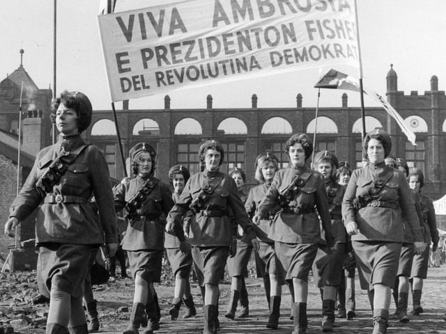 A scene being shot on location at a site off Green Lane, with Green Lane Primary School in the background. This scene, which shows a group of women marching under a banner proclaiming 'Viva Ambrosia', is part of a dream world imagined by the character Billy Fisher.