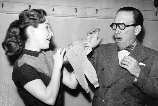 Arthur Askey registers amazement at the size of his garment after his daughter Anthea has shrunk it in the wash. The pair were appearing in The Love Match at the theatre in October 1955.