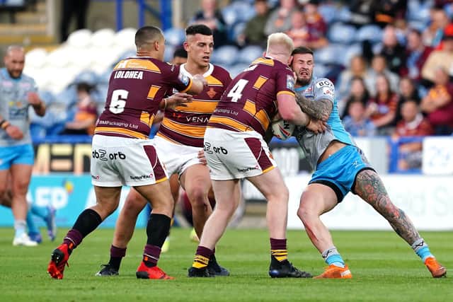 Leeds Rhinos' Zac Hardaker (right) is tackled by Huddersfield Giants' Tui Lolohea (left), Owen Trout and Matty English at the John Smith's Stadium Picture: Martin Rickett/PA