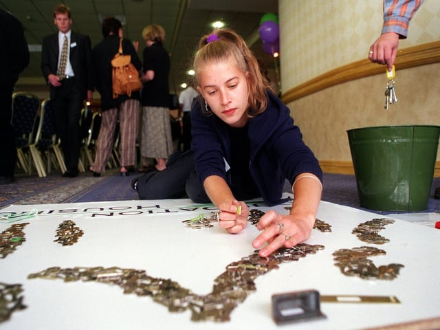 Freelance artist and writer Kath Jones works on a 3D wall picture made from 3,000 door keys at the launch of Foundation Housing, formerly the Timble Housing Project, in Leeds.