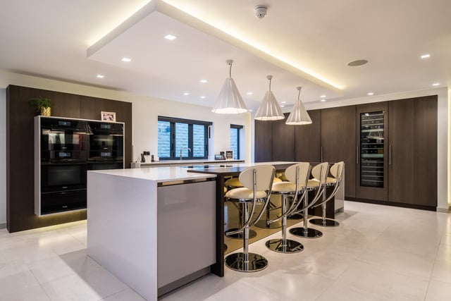 The central island in the sleek and well equipped kitchen includes a breakfast bar.