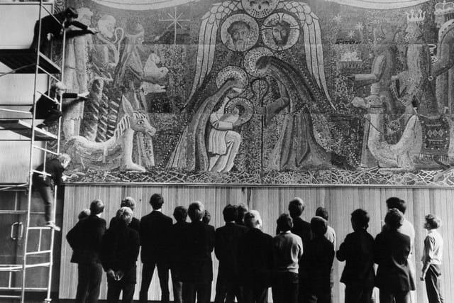 Pupils at St. John Bosco School on Tongue Lane in Meanwood look at a giant mosaic of the Nativity which has been made of coloured pieces of paper cut from magazines and foil from cigarette packs in December 1969.