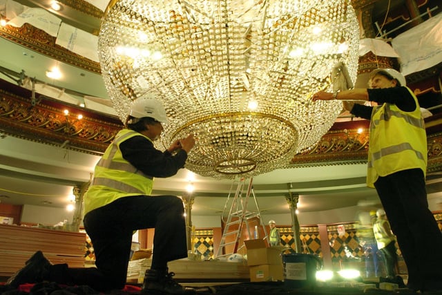 Leeds Grand cleaners Michael Wilks (left) and Sheila Coates help clean the huge chandelier as part of the theatre's refurbishment in June 2006.
