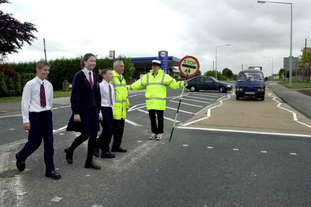 Jan Ramsay safely oversees the crossing of Garforth Community College pupils, Thomas Spurr, Faye Hartley and James Allinson with Mark Schofield, route manager with Leeds City Counci;l's Highways Department in June 2000.