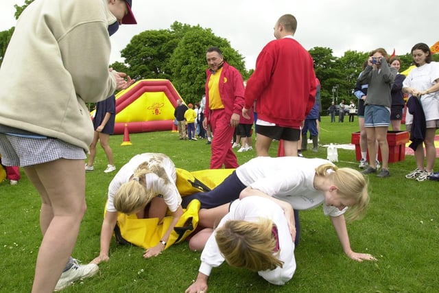 A team of competitors in the sack race collapse during the It's a Knockout corporate challenge at Beckett Park.