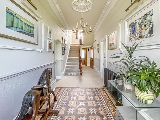 The long and light hallway has a staircase leading up the first floor.