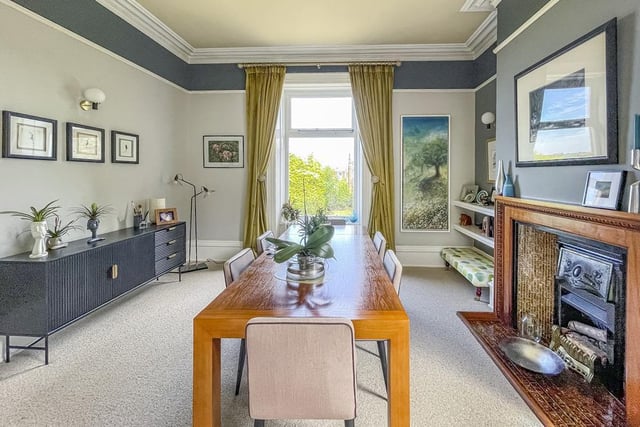 The dining room is made bright by two windows, and has a gas fire within a wooden and tiled mantlepiece setting.