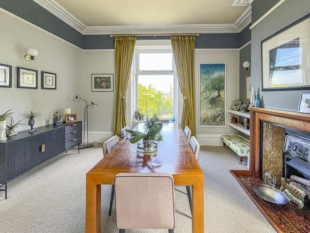 The dining room is made bright by two windows, and has a gas fire within a wooden and tiled mantlepiece setting.