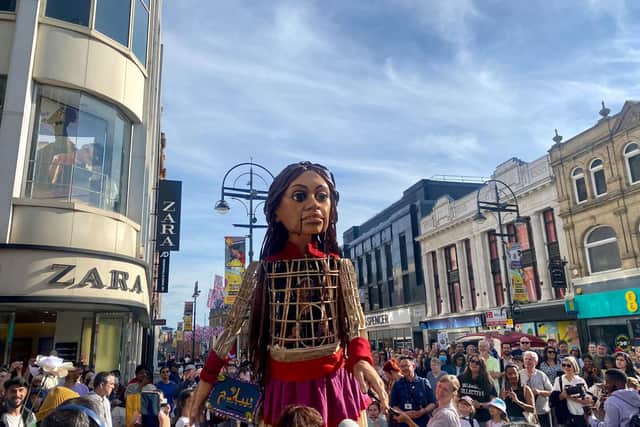 The giant puppet of a 10-year-old Syrian refugee made her way from Briggate to Millennium Square