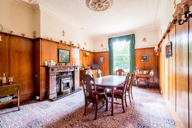The panelled dining room with picture rail has a central fireplace and plenty of natural light.