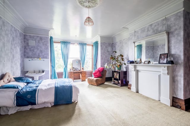 A large bay window and fireplace add to the appeal of this double bedroom with wash facilities.
