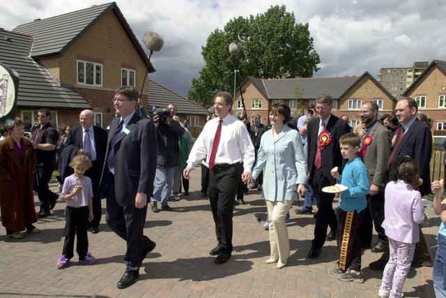 Tony Blair and wife Cherie walk through the new housing development in the Lincoln Green area.