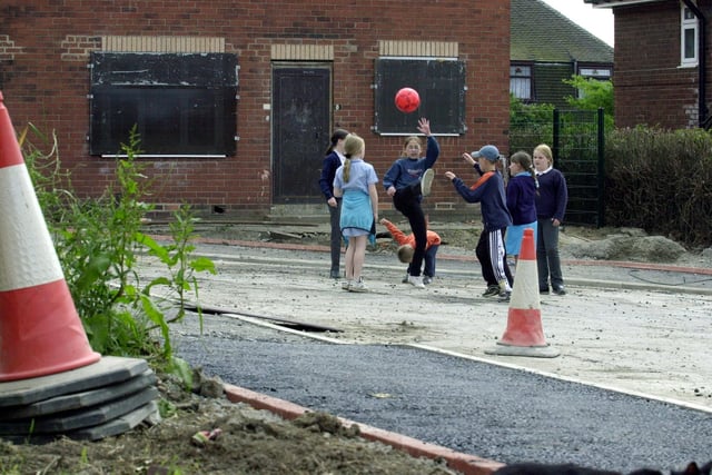 Youngsters play football amongst the debris left by Leeds City Council during work to properties on Grayrigg Close in Halton Moor.