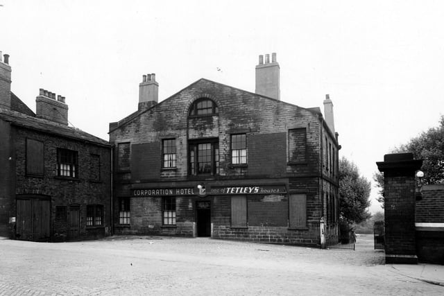 The rear of the Corporation Hotel, formerly Campfield House, on Camp Road in May 1950. The hotel and the building next door both have bricked up windows. Iron gates are on the right and a cobbled yard is in the foreground.