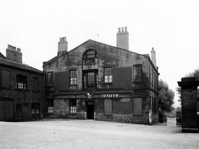 The rear of the Corporation Hotel, formerly Campfield House, on Camp Road in May 1950. The hotel and the building next door both have bricked up windows. Iron gates are on the right and a cobbled yard is in the foreground.