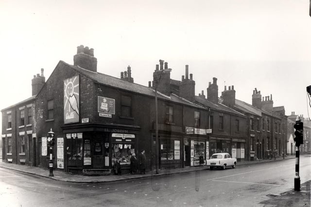 The junction of Meanwood Street and Meanwood Road in April 1958.  The corner shop was the business of I.L. Joseph, selling boots and shoes. Resting against the window is a member of the Higgins family, who kept a fish mongers shop on Meanwood Road.