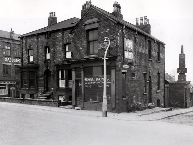 On the left, part of the Victory Halls, dating from 1922 can be seen, used as the premises of Sasson's Tailors Ltd. At the corner of the ground floor is Sydney's, gents hairdresser on Camp Road.