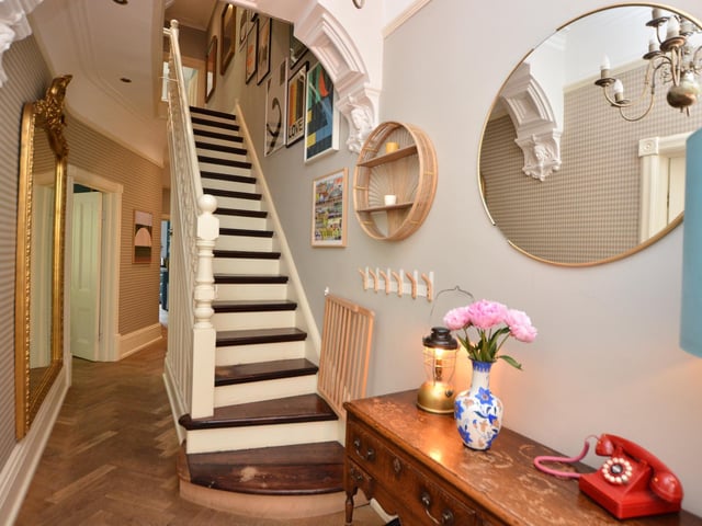 A ground floor entrance hall has lovely decorative features including an original front door with stained and etched glass panels, ceiling cornicing with moulded arch and staircase to the first floor with original spindled balustrade.