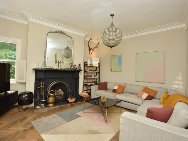 Off the hallway is a beautiful living room which has an attractive period fireplace and open fire.