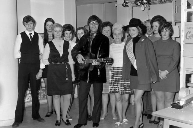 Cliff Richard taken at Green Shield Stamps on Eastgate in April 1970. He is surrounded by a group of staff dressed in typical fashion of the time.