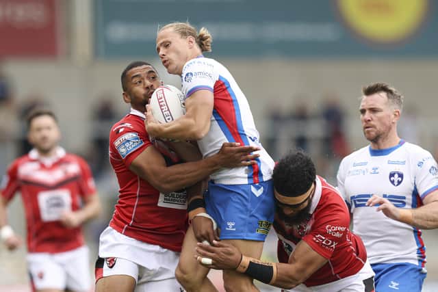 Wakefield Trinity captain Jacob Miller is wrapped up by Salford Red Devils pair Kallum Watkins, left, and Sitaleki Akauola. Picture: Paul Currie/SWpix.com.