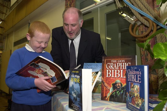 Doc Ray Baker from Morley Community Church hands over books to Cross Hall Junior School in September 2001. He is pictured with Brenndan Chadwick.