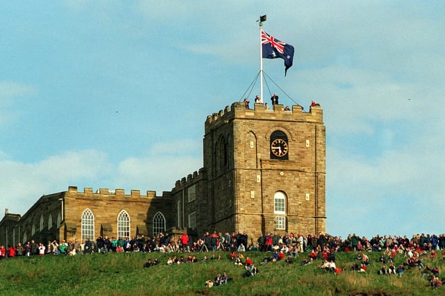 Sightseers at St Mary's Church high above Whitby Harbour wait for the arrival of the replica of HMS Endeavour in May 1997.