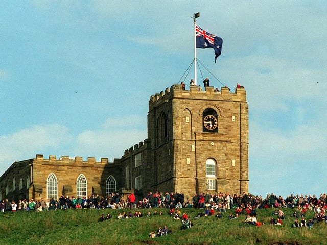 Sightseers at St Mary's Church high above Whitby Harbour wait for the arrival of the replica of HMS Endeavour in May 1997.