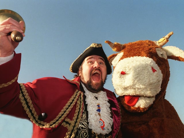 The British Champion Town Crier Andy Lowe from Whitby and Robin Hoods Bay proclaims the lifting of the beef export ban with the help of a pantomime cow in November 1998.