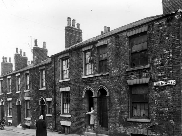 A woman stands at the door of a derelict house on East Beckett Street in May 1960. The property was to be included in clearance area,