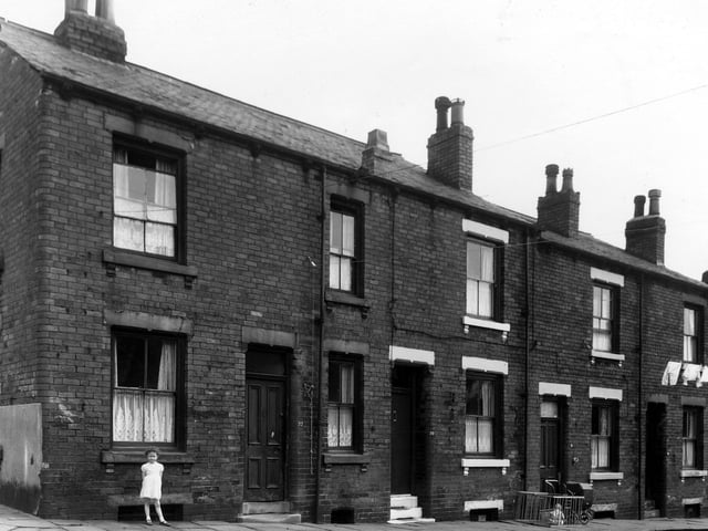 A little girl is standing outside a house on Leith Street in May 1960.