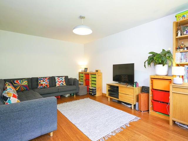 A large window to the front elevation of the living room floods it with natural lighting, complimenting the decor and bamboo wood flooring.