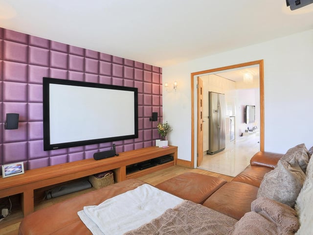 With a window to the front elevation, the living room is flooded with natural lighting complimenting the tasteful decor. Solid oak wood flooring runs throughout, with a projector screen with projector and surround sound installed.