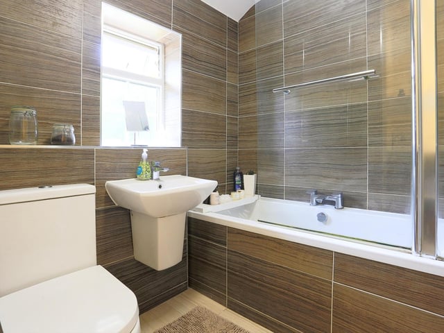 The house bathroom is fitted with a modern three-piece suite, comprising of a bath with shower over, wall-mounted wash hand basin and low level flush toilet.