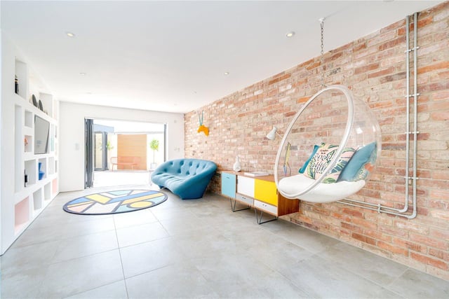 An exposed brick wall and 'floating' chair feature in this spacious room.