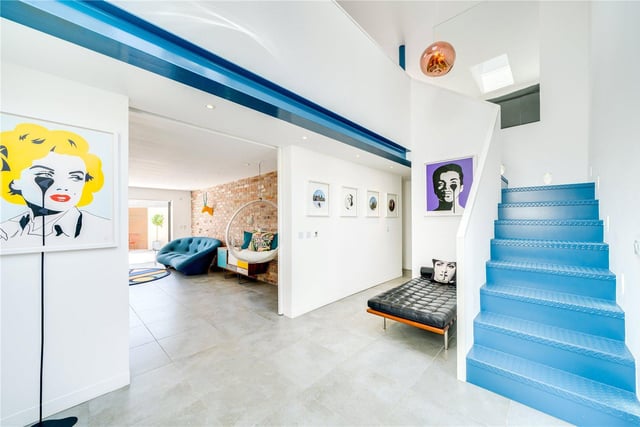 A bespoke powder coated blue staircase and exposed steel work feature in the hallway.