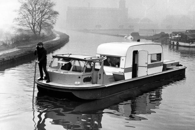 A caravan sets sail in a specially designed boat on the Leeds Liverpool Canal in January 1971.