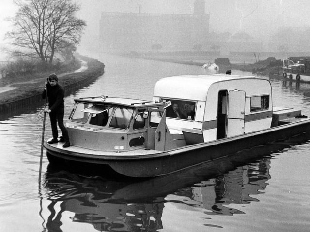 A caravan sets sail in a specially designed boat on the Leeds Liverpool Canal in January 1971.