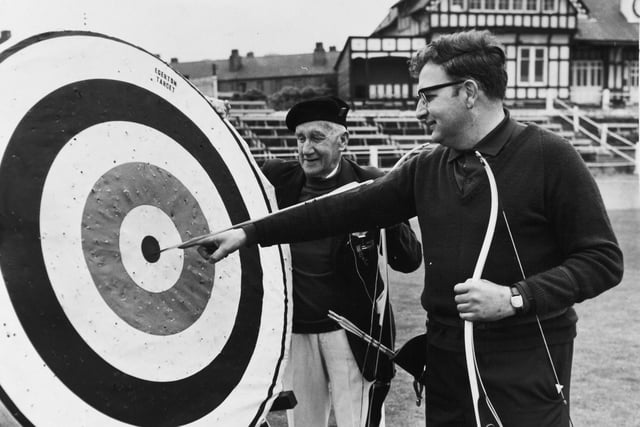 Martin Seeber points to the spot where his arrow landed to win him tyhe Scorton Silver Arrow contest in June 1971. The oldest competitor, Ben Hird, looks on.