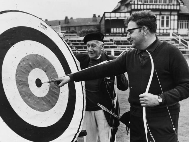 Martin Seeber points to the spot where his arrow landed to win him the Scorton Silver Arrow contest in June 1971. The oldest competitor, Ben Hird, looks on.