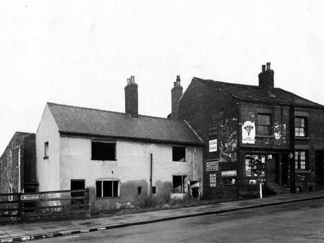 Millshaw Lane showing Squire Brown's grocers shop next to two derelict cottages in December 1942.