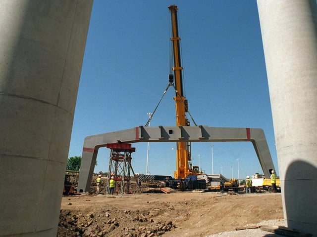 The giant steel support weighing over 100 tonnes with a span of 26 metres is lowered into position. The structure will carry traffic signs on a new link road between the M1 and the M621 south bound from the city when finished.